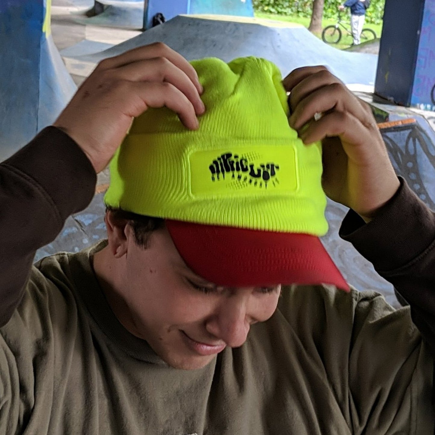smiling man wearing a hippielit beanie over his hat